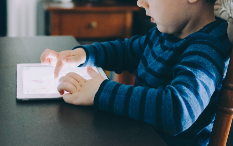 Child playing on a screen. Too much screen time.
